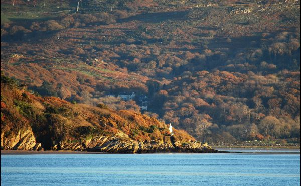 blue water with coastline and tree lined hills in the background